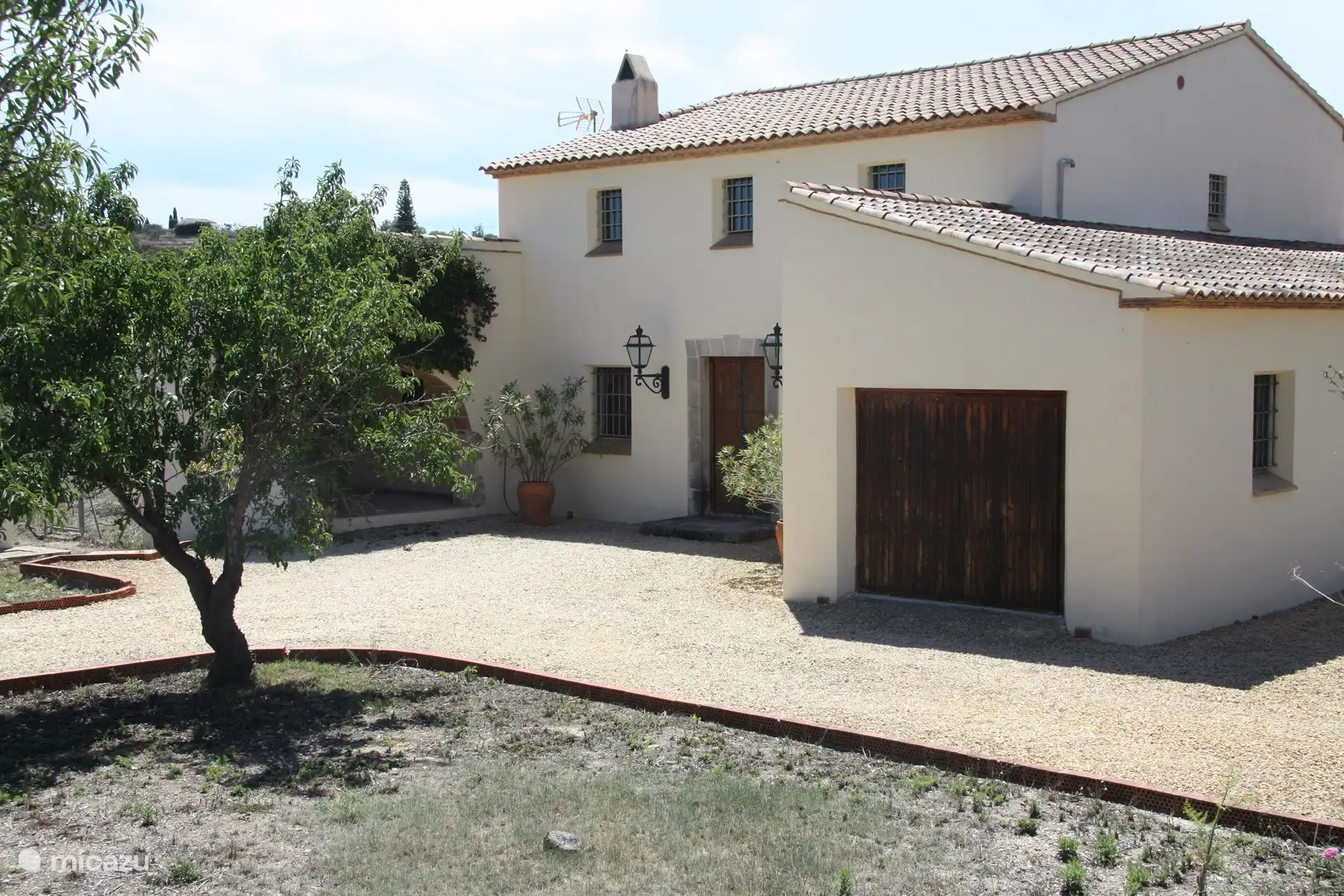 Vor dem Haus mit eingebauter Garage.