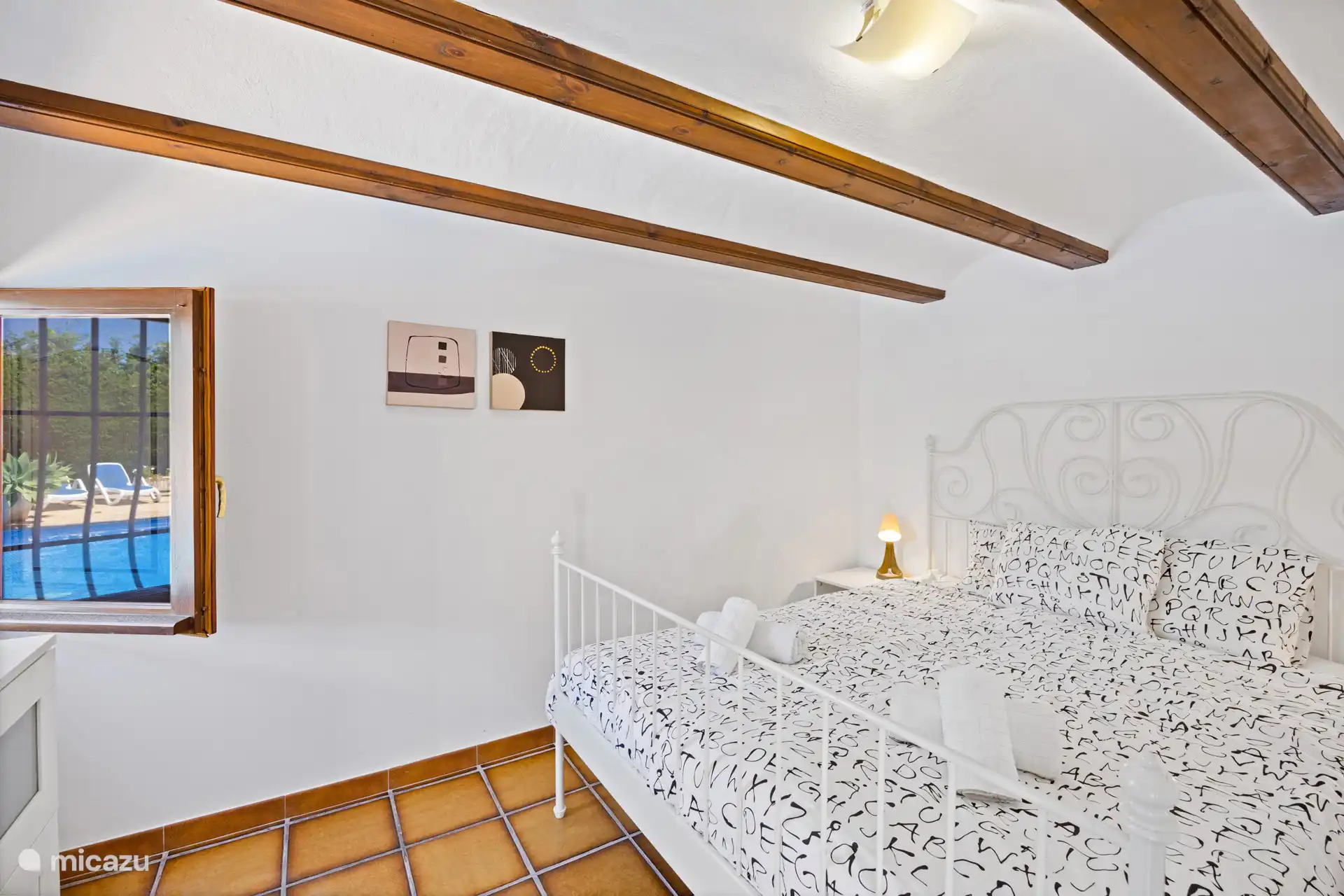 Wakker worden en door het raam direct uitkijken op het zwembad — dat is pas goed beginnen! Een sfeervolle slaapkamer met houten balken en het mooiste uitzicht als wekker.