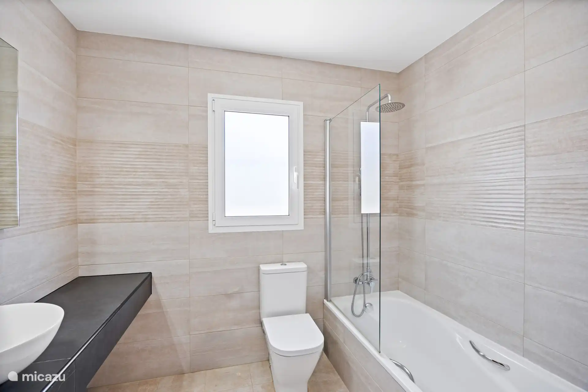 Liever een bad of toch een douche? In deze stijlvolle, moderne badkamer hoef je geen keuze te maken. Lekker bijkomen na een dag in de Spaanse zon!
