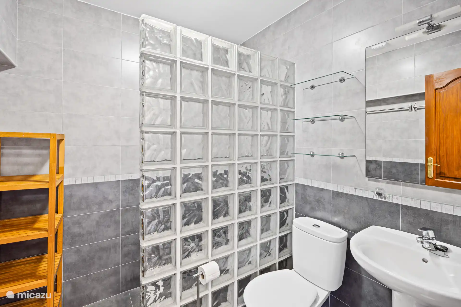 Comfortabel en compleet. Een verzorgde badkamer met douche, bidet en een karakteristieke glazen blokwand  alles klaar voor een zorgeloze vakantie!