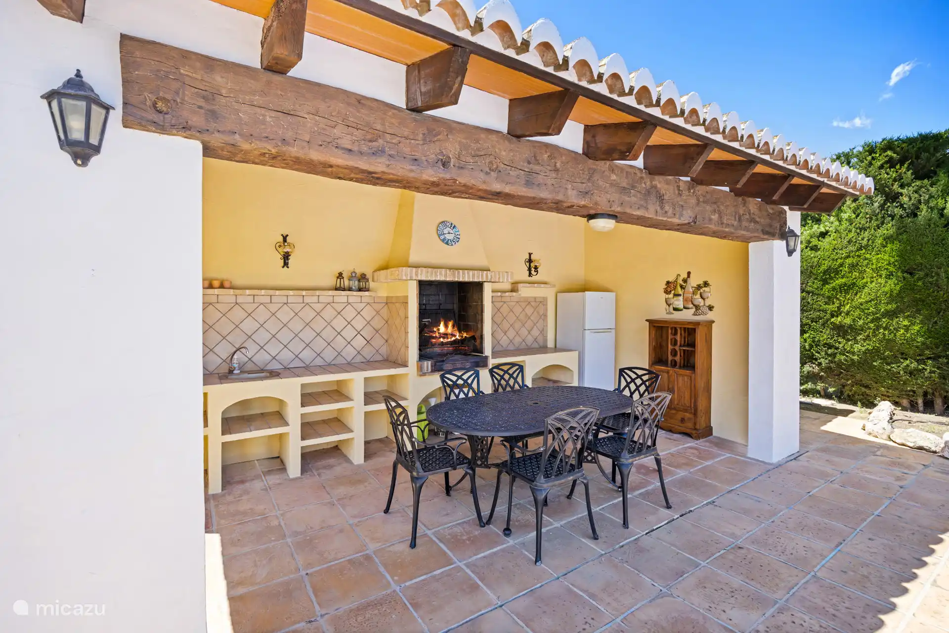 Buiten eten op zijn Spaans! Dit sfeervolle overdekte terras met ingebouwde barbecue, grote eettafel en houten balken is dé plek voor gezellige avonden met het hele gezelschap.