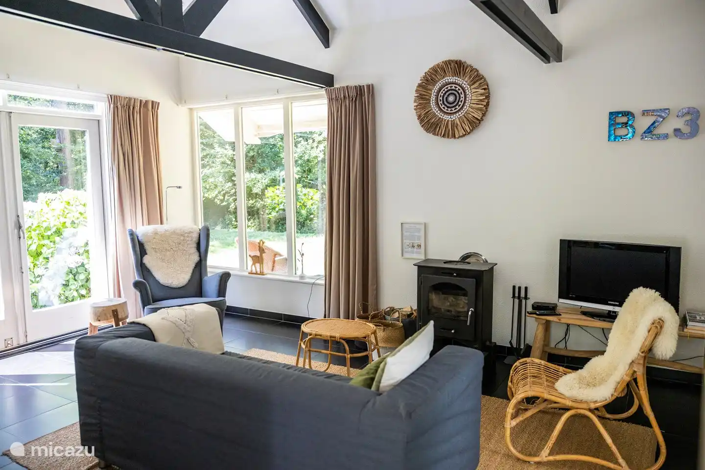 Ansprechend eingerichtetes Wohnzimmer mit Blick auf den Wald.