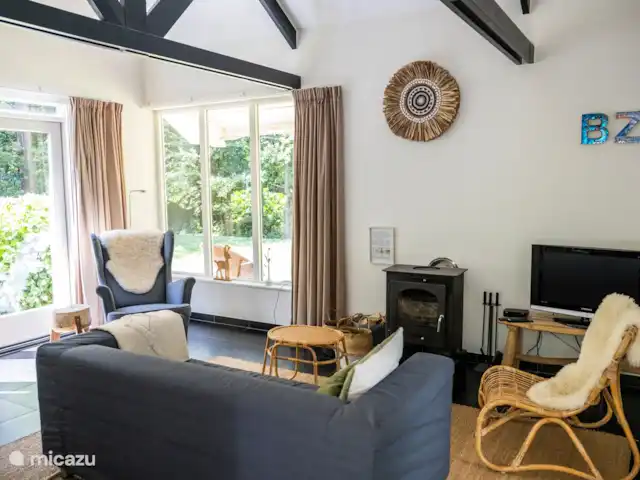 vakantiehuis huren in Nederland, Friesland, Oudemirdum – Vakantiehuis Friesland Sfeervol ingerichte woonkamer met uitzicht op het bos.