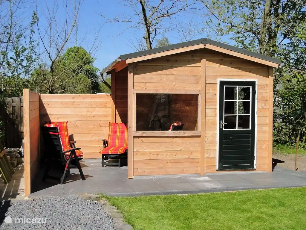 Blockhaus und Vordach mit Windschutz aus Holz