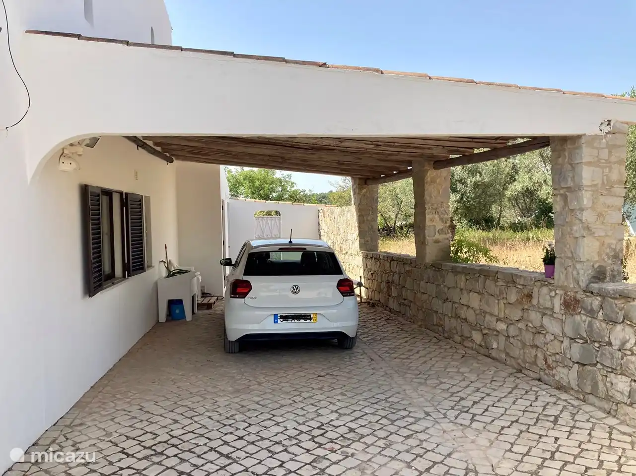 Su coche está a la sombra bajo la espaciosa cochera