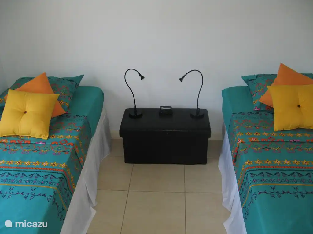 Kibrahacha A28 : Chambre avec deux lits simples, une armoire ouverte et un climatiseur split-unit.