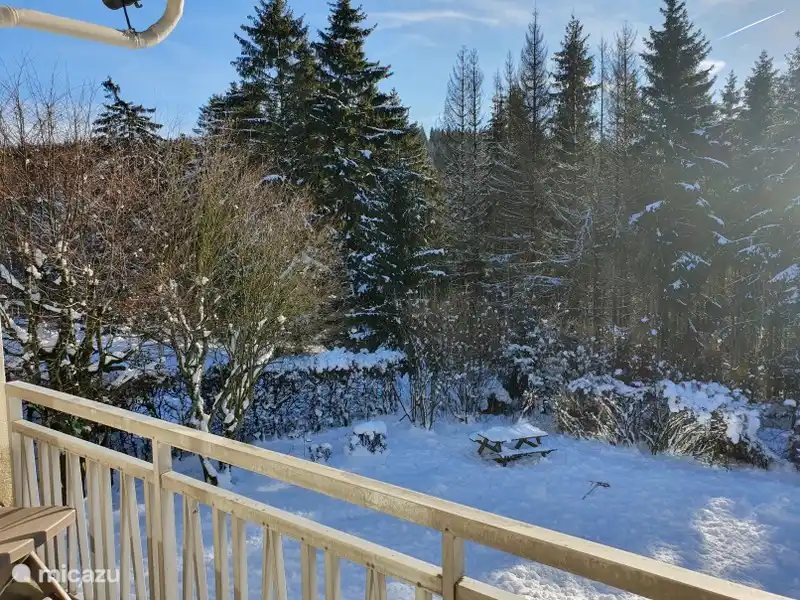 Bedroom balcony with seating and garden view.