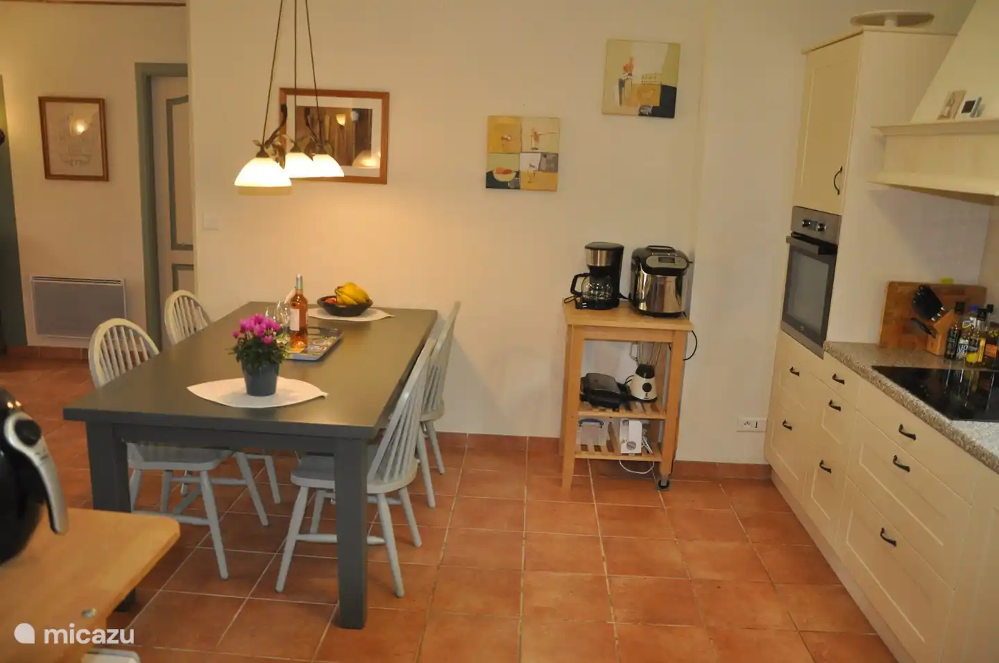 Esstisch und Küche mit Backofen und diversen Geräten