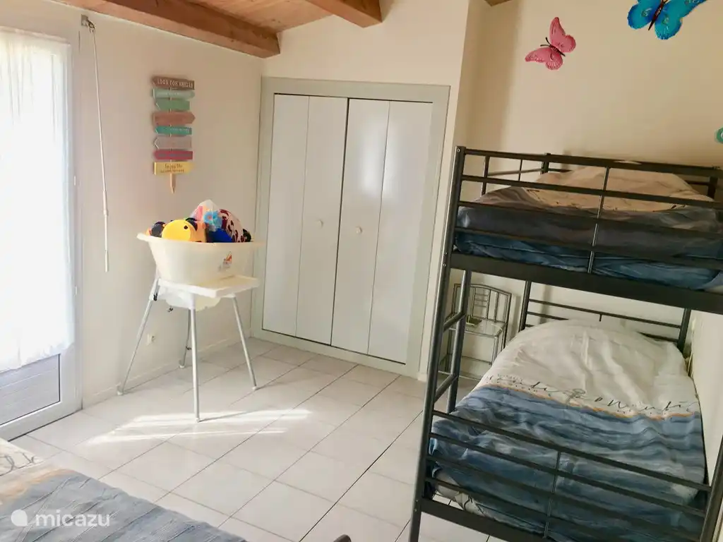 Children's room with bunk and single bed. Fitted wardrobe and access to the terrace