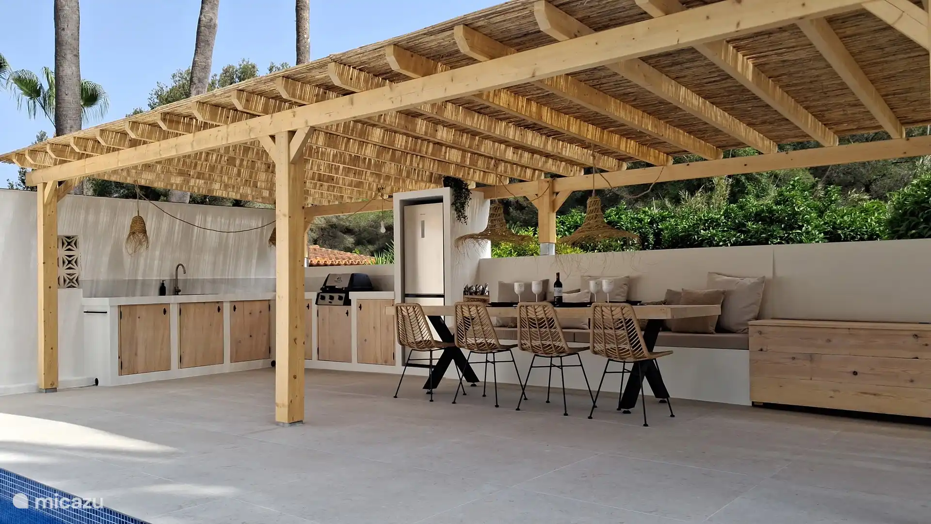 La cocina al aire libre tiene una nevera grande y una barbacoa Broil King. En otras palabras... Ase a la parrilla y luego cene en la mesa tamaño king.