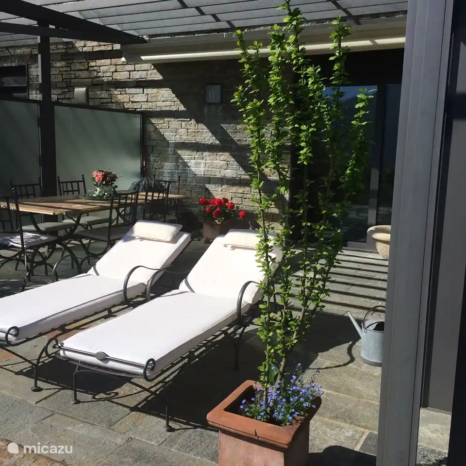 Frente al dormitorio con puertas correderas, se encuentra la barbacoa, una mesa de comedor con 6 sillas y 2 tumbonas ajustables con colchón grueso.
Esta terraza tiene un techo corredizo eléctrico.