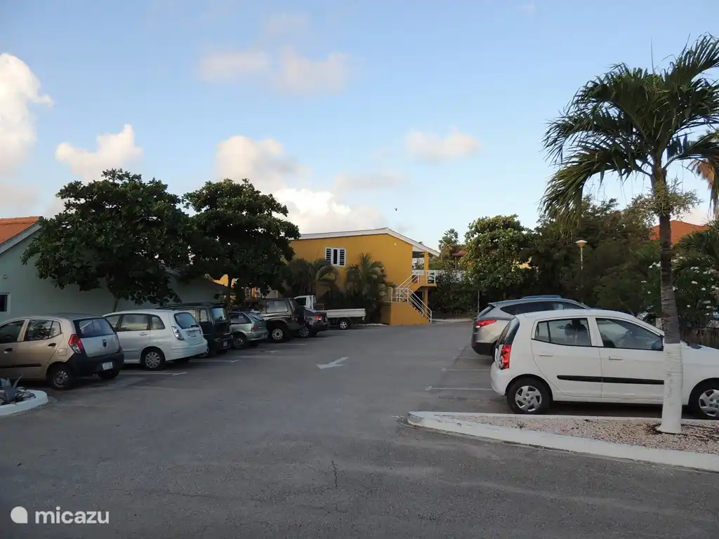 Amplio espacio de estacionamiento frente al apartamento. A lo lejos la pared lateral con la gran ventana lateral del apartamento. El apartamento está convenientemente ubicado en el viento.