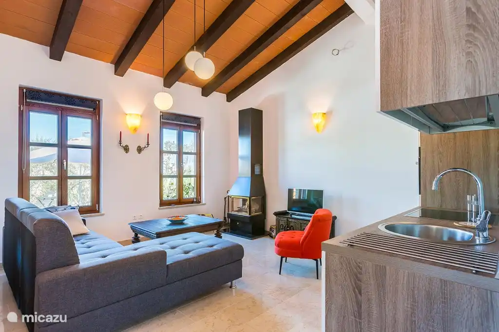 Salón con cocina abierta. La cocina está totalmente equipada y hay un comedor interior con mesa para 6 personas. En los meses de otoño es maravilloso tomar una copa de vino junto a la chimenea.