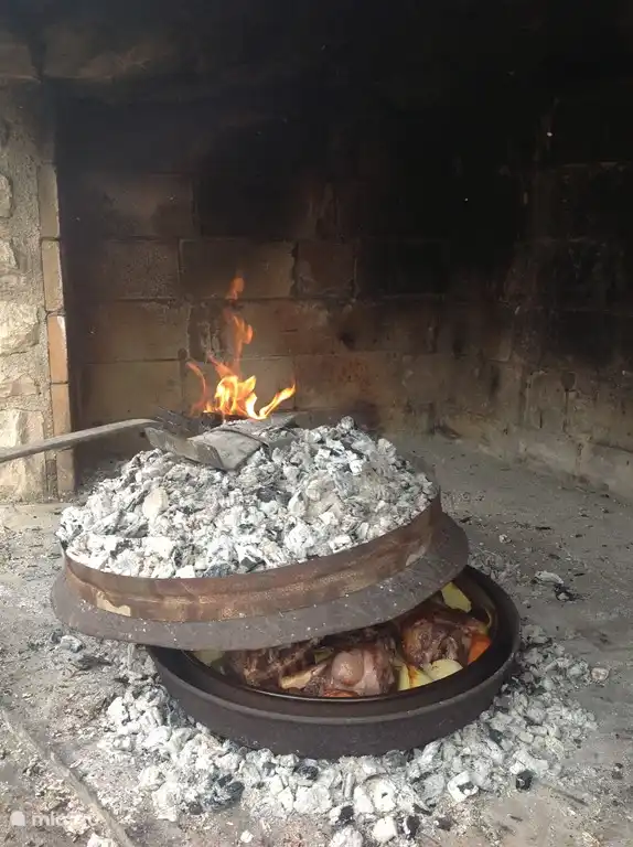 Elaboración tradicional de carnes y verduras en nuestra barbacoa de piedra.