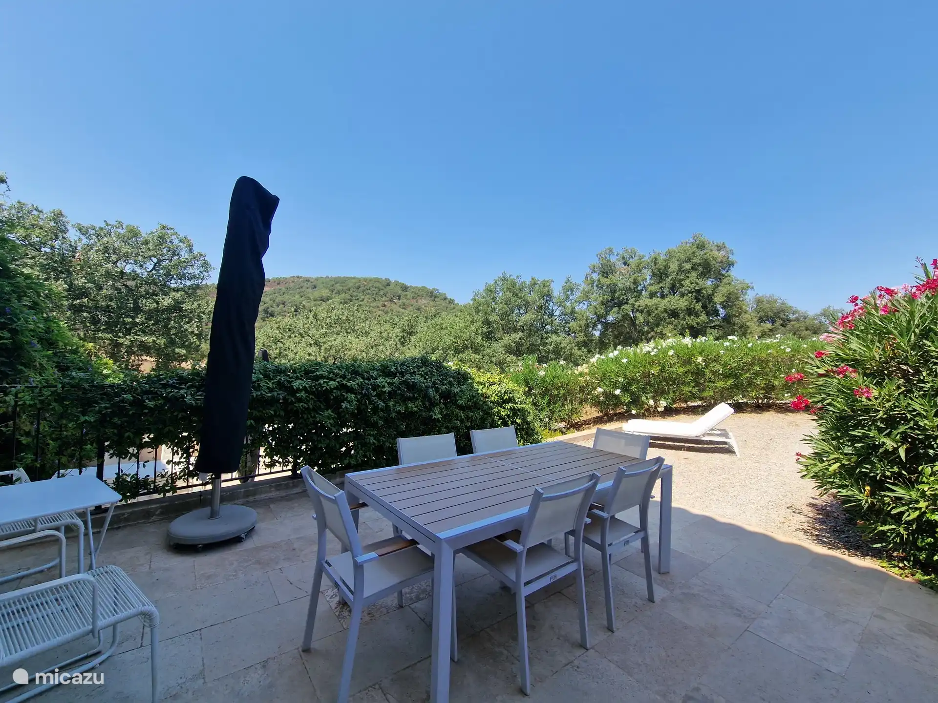 Terraza con zona de comedor y sombrilla