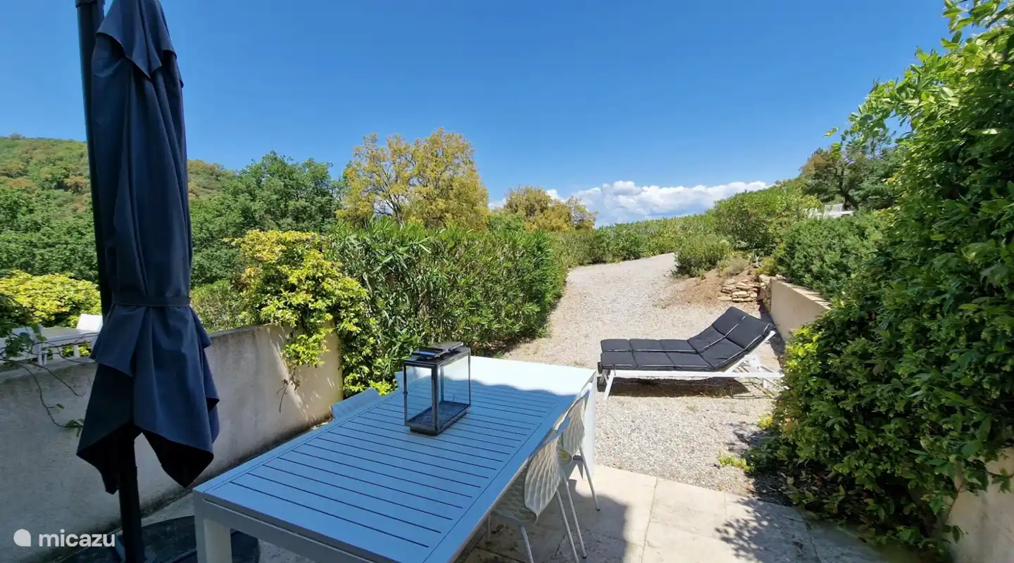 Terrace with dining table and sunbeds