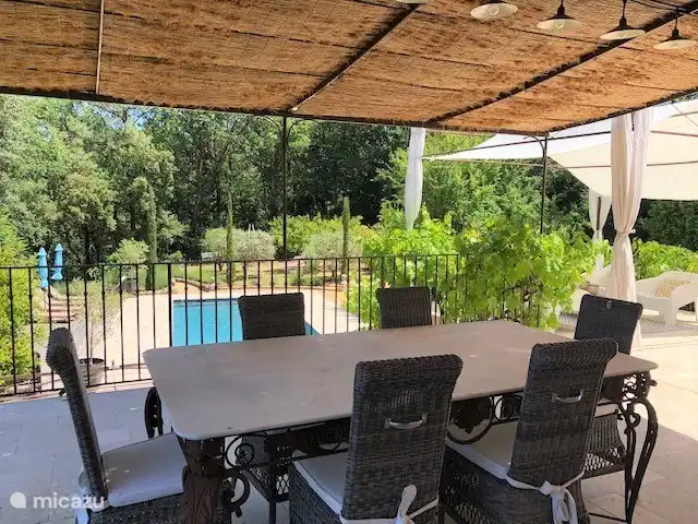 Die Terrasse mit Marmor-Esstisch und 6 gepolsterten Stühlen und Blick auf den Pool