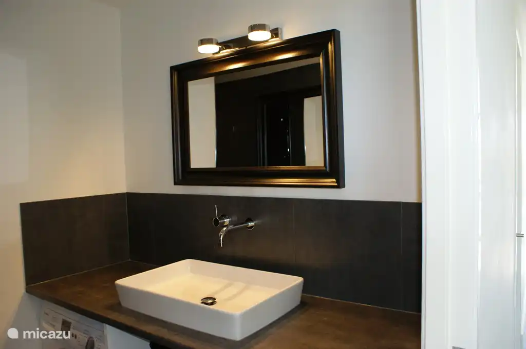 Badezimmer mit Dusche, Waschmaschine und Trockner.