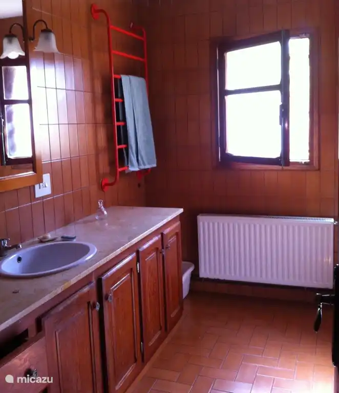 Badezimmer mit Badewanne/Dusche und WC. Es gibt einen Fön, Bügeleisen, Erste-Hilfe-Kasten.