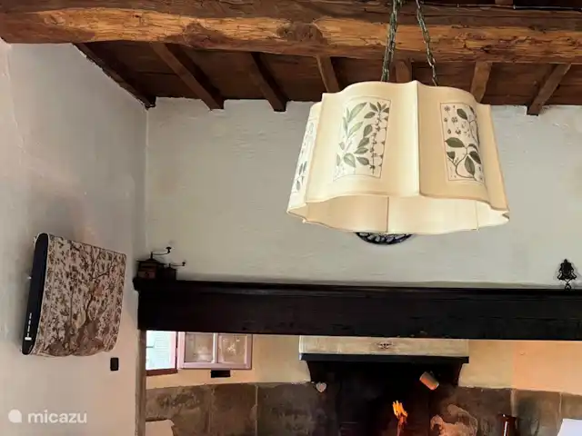 Valpiana | Italie, Toscane, Rufina - villa Salon au rez-de-chaussée avec grande cheminée fermière de 1600. Dans le salon, il y a des canapés et des fauteuils, une table avec des chaises, une table basse, une armoire avec des vins, des livres et des jeux de table.