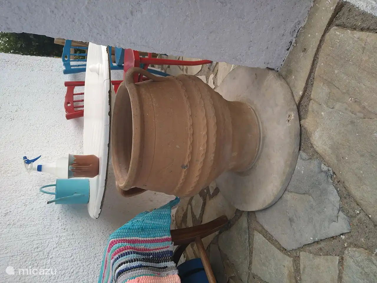 Tuin met stoeltjes en mooie kruik