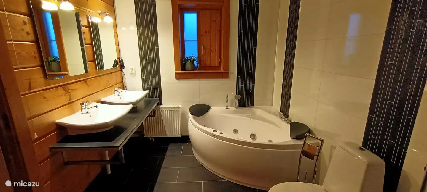 Im Erdgeschoss ein geräumiges Badezimmer mit zwei Waschbecken und Whirlpool