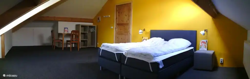 Das geräumige gelbe Zimmer mit Doppelbett, Boxspringbett. Dieses Zimmer hat auch ein Dachfenster mit Blick auf den See.