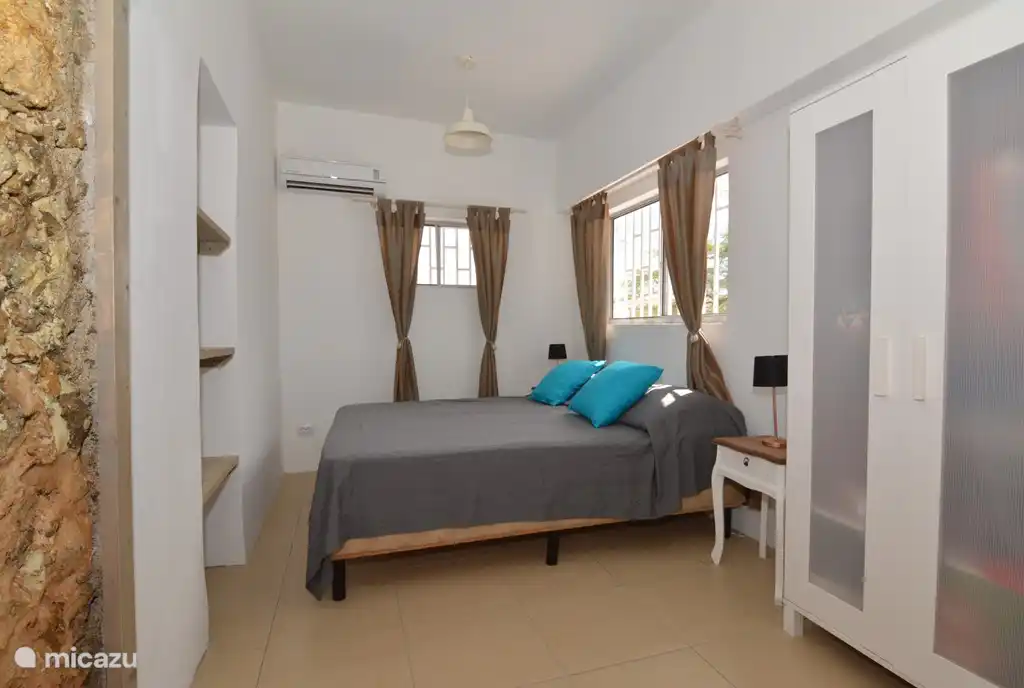 La chambre parentale avec un tableau du style immeuble ancien sur Bonaire à gauche