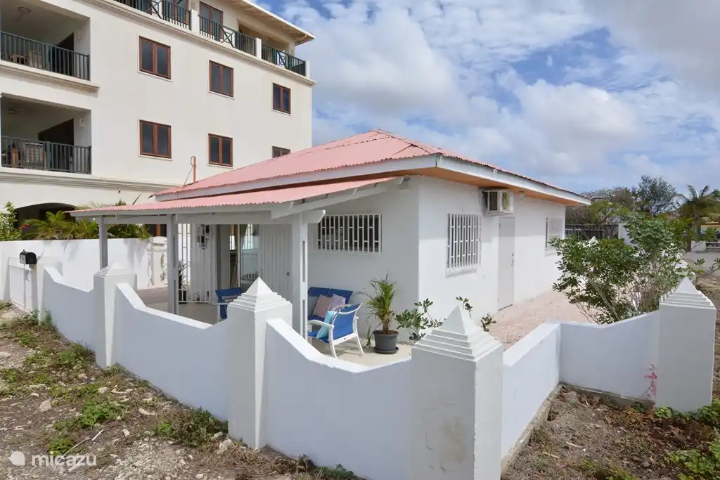 Vue de face de la maison avec l'espace de stationnement privé pour une voiture sur la gauche. Il y a aussi un espace derrière la maison pour se garer.