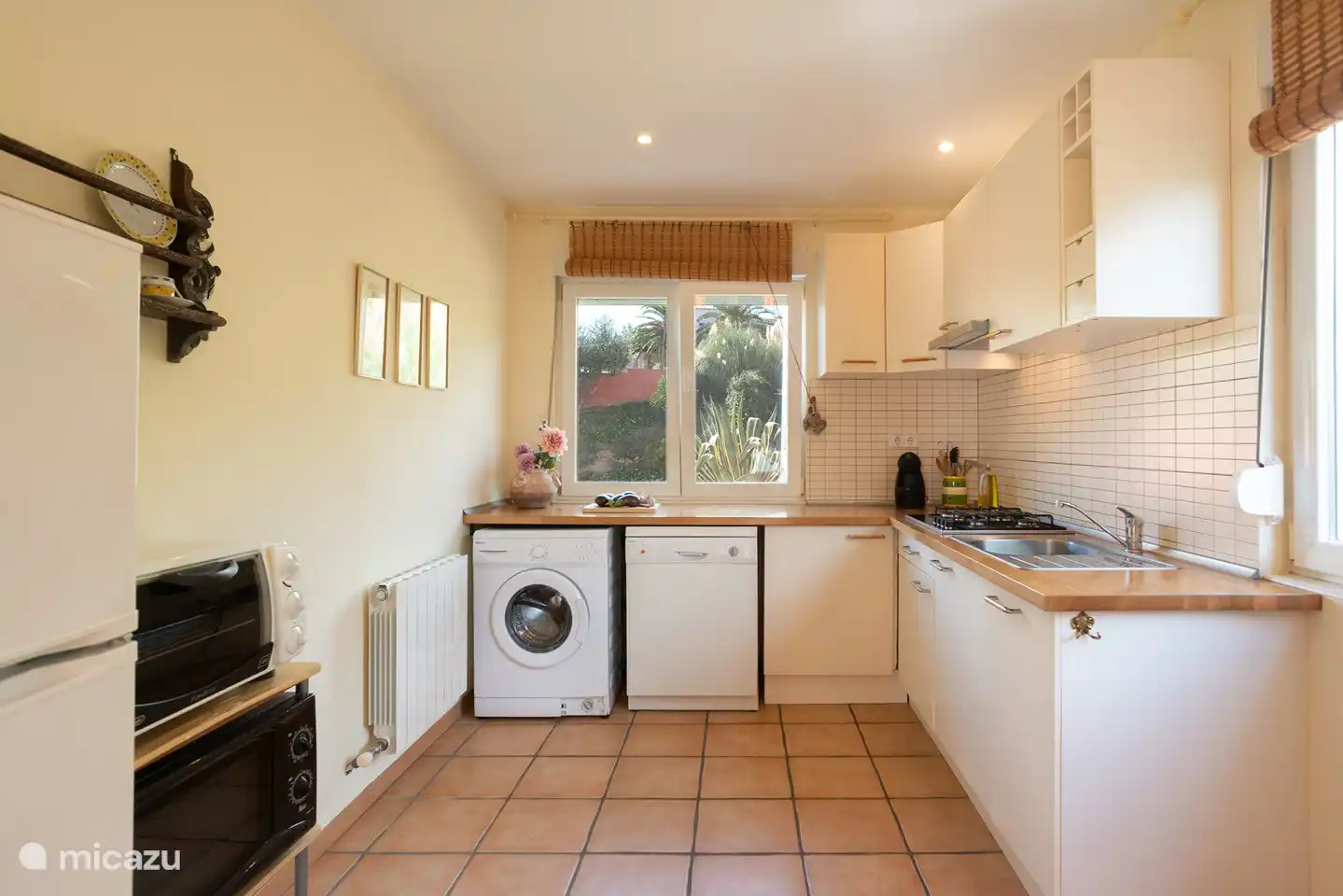 Separate Küche mit L-förmiger Arbeitsplatte. Waschmaschine, Geschirrspüler, Dolce Gusto, Backofen, Kühl- und Gefrierschrank.
Gasherd.