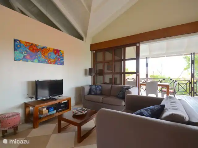 Villa directamente en la playa de Blue Bay en Curazao, Curazao Centro, Blue Bay - villa ¡La sala de estar con Apple TV, juegos de mesa, lectura de libros y folletos sobre Curaçao!