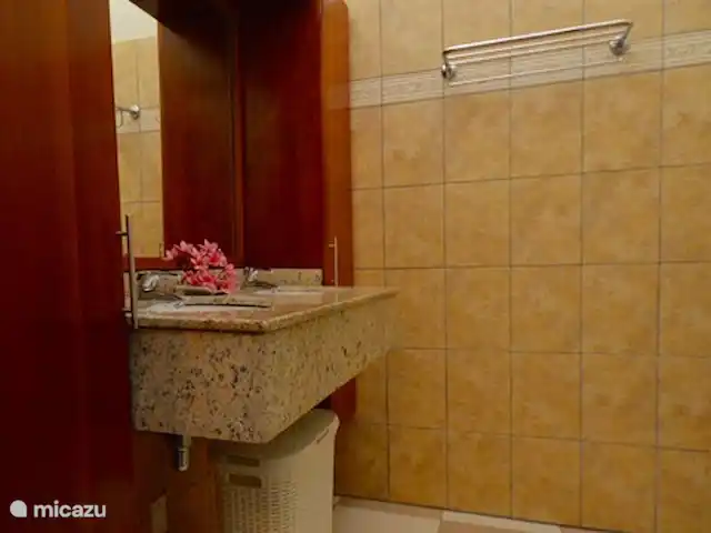 Villa directamente en la playa de Blue Bay en Curazao, Curazao Centro, Blue Bay - villa Cuarto de baño 1 con 2 lavabos, ducha a ras de suelo e inodoro colgante.