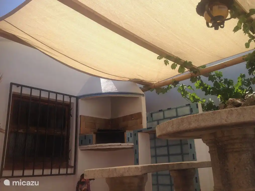 Rund um das Haus gibt es mehrere Terrassen, darunter einen Grillplatz unter der Traube.