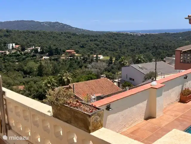 Von der Terrasse im Schatten der Markise haben Sie einen Blick auf den Pool und das Meer. Hier verbringen Sie den lauen Abend. In der Ferne kann man die Stadt sehen, die nachts beleuchtet ist.