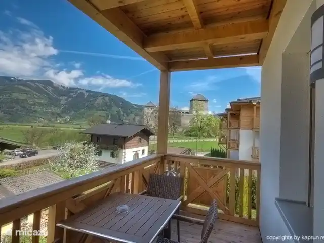 appartement huren in Oostenrijk, Salzburgerland, Kaprun – Residenz an der Burg Top6 Huis B Vanaf de living heeft u direct toegang tot het balkon vanaf waar u een schitterend uitzicht heeft over het dorp, de gletsjer Kitzsteinhorn en de omliggende bergen.