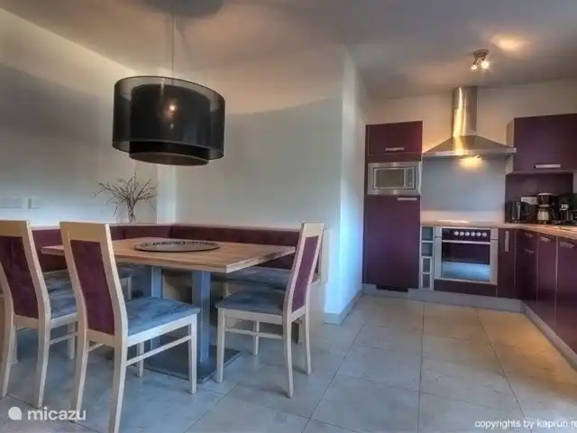 appartement huren in Oostenrijk, Salzburgerland, Kaprun – Residenz an der Burg Top6 Huis B De living is verdeeld in een luxueuze vol uitgeruste open keuken, ruime zithoek en een woonkamer die is voorzien van een open haard, waar u na een dag van het buitenleven genoten te hebben heerlijk kunt bijkomen onder het genot van een drankje.