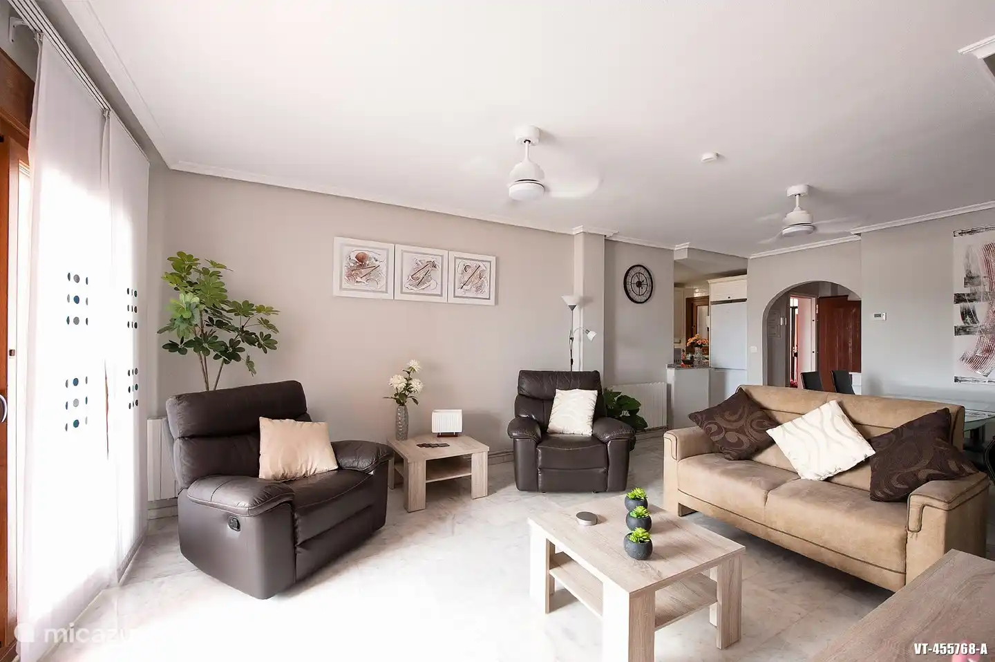 Woonkamer ingericht met 2 relaxfautteuls een tweezitsbank, Flatscreen TV met Nederlandse zenders.