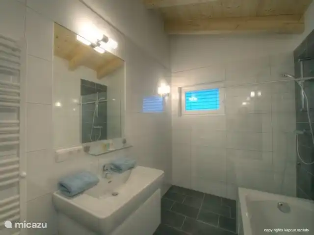 Residencia Kitzsteinhornblick Top2 en Austria, Salzburgo, Zell am See - penthouse Hay 2 baños amplios y lujosos, un aseo independiente y un lavadero.