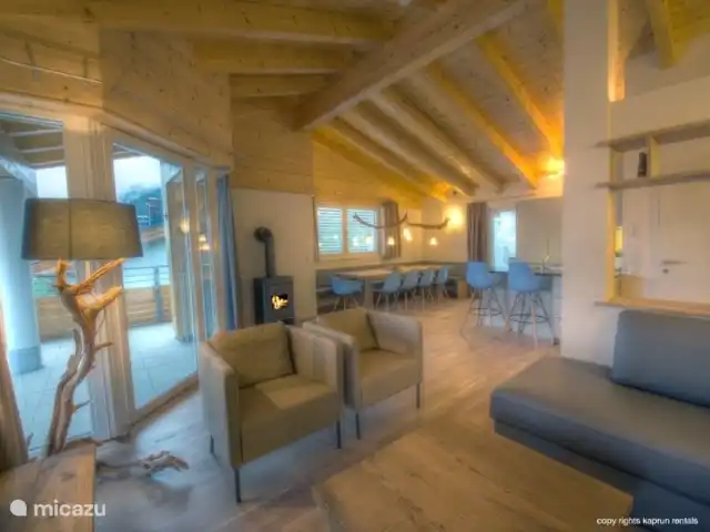 Residencia Kitzsteinhornblick Top2 en Austria, Salzburgo, Zell am See - penthouse Los techos altos con vigas de madera dan la máxima sensación de un ático. La maravillosa sala de estar abierta con chimenea, la espaciosa sala de estar y la lujosa cocina la completan. Desde el sofá puede recordar unas vacaciones exitosas, mientras disfruta de un refrigerio.