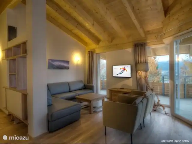 Residencia Kitzsteinhornblick Top2 en Austria, Salzburgo, Zell am See - penthouse Los techos altos con vigas de madera dan la máxima sensación de un ático. La maravillosa sala de estar abierta con chimenea, la espaciosa sala de estar y la lujosa cocina la completan. Desde el sofá puede recordar unas vacaciones exitosas, mientras disfruta de un refrigerio.