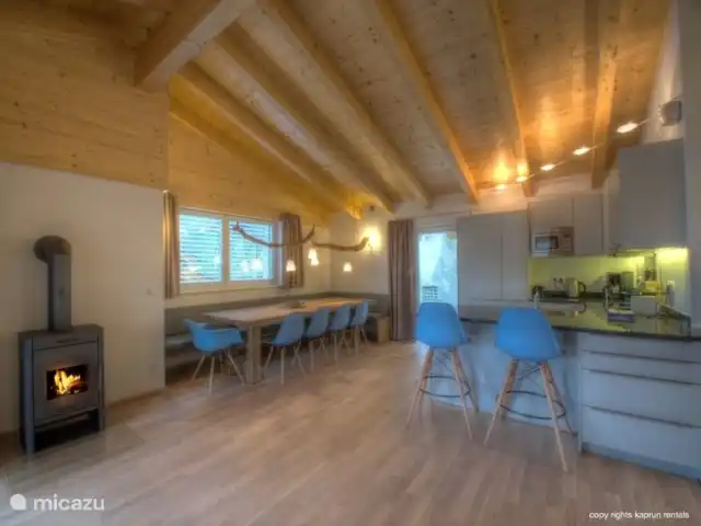 Residencia Kitzsteinhornblick Top2 en Austria, Salzburgo, Zell am See - penthouse Los techos altos con vigas de madera dan la máxima sensación de un ático. La maravillosa sala de estar abierta con chimenea, la espaciosa sala de estar y la lujosa cocina la completan. Desde el sofá puede recordar unas vacaciones exitosas, mientras disfruta de un refrigerio.