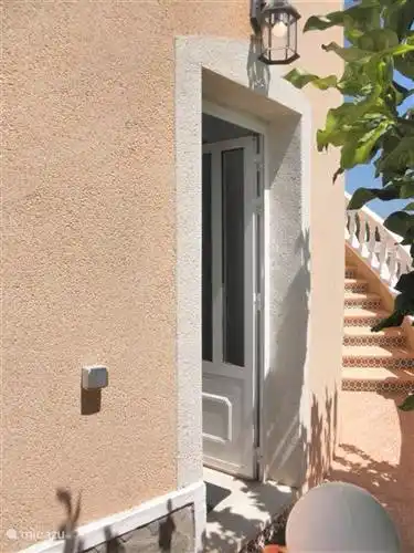 voordeur van het appartement nadat je naar beneden bent gelopen vanaf de buitentrap