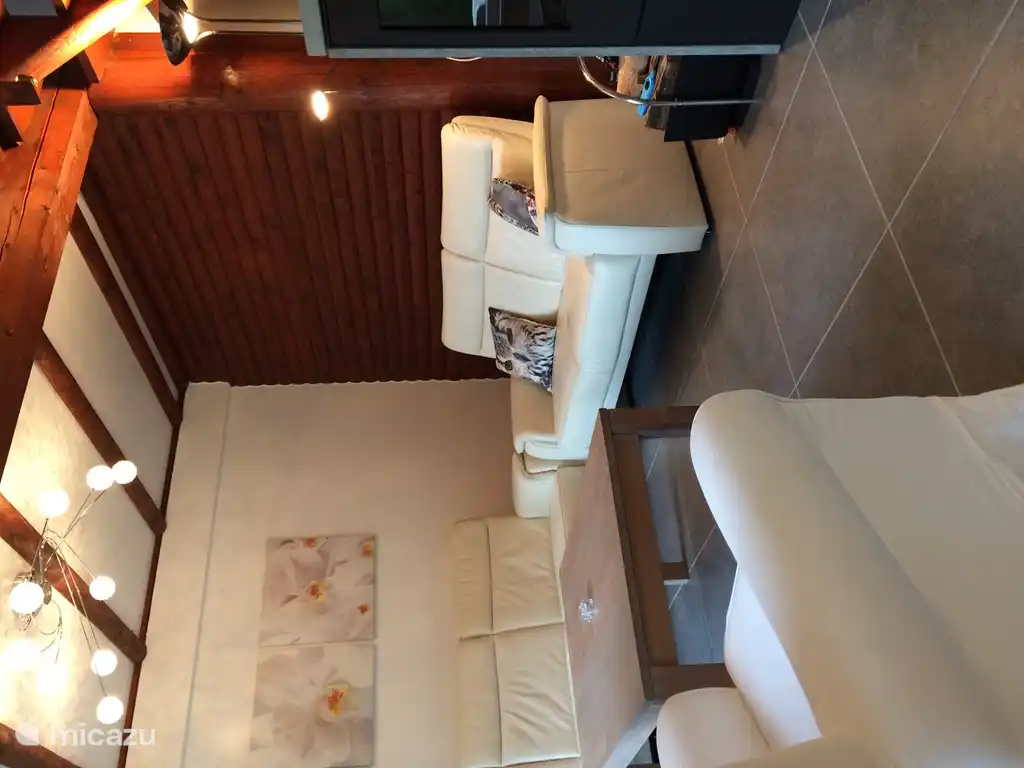 Wohnzimmer mit Leselampe. Großer hoher Couchtisch, an dem auch Kleinkinder spielen können.