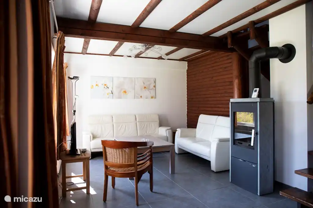 Wohnzimmer, hochwertige Ledersofas, Poang Ikea-Stoffstuhl anstelle des Holzstuhls, Couchtisch, Leselampe, Blick auf die Terrasse / Rasen im Süden. Holzofen aus Gusseisen (neu) statt Speckstein. heizte die Hütte viel schneller. Holz inklusive 