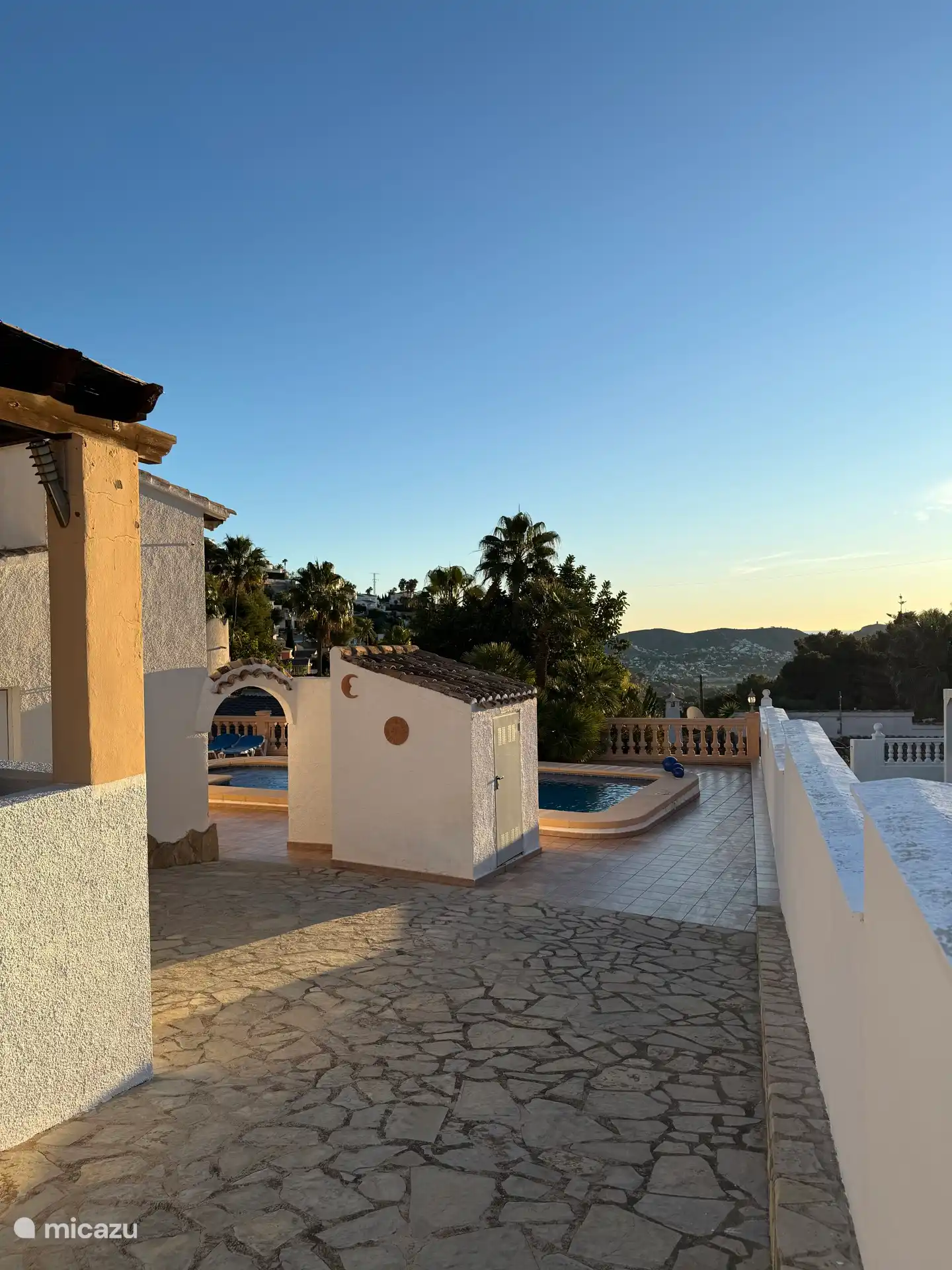 Desde la entrada de la entrada de la cabaña, la ducha exterior junto a la piscina