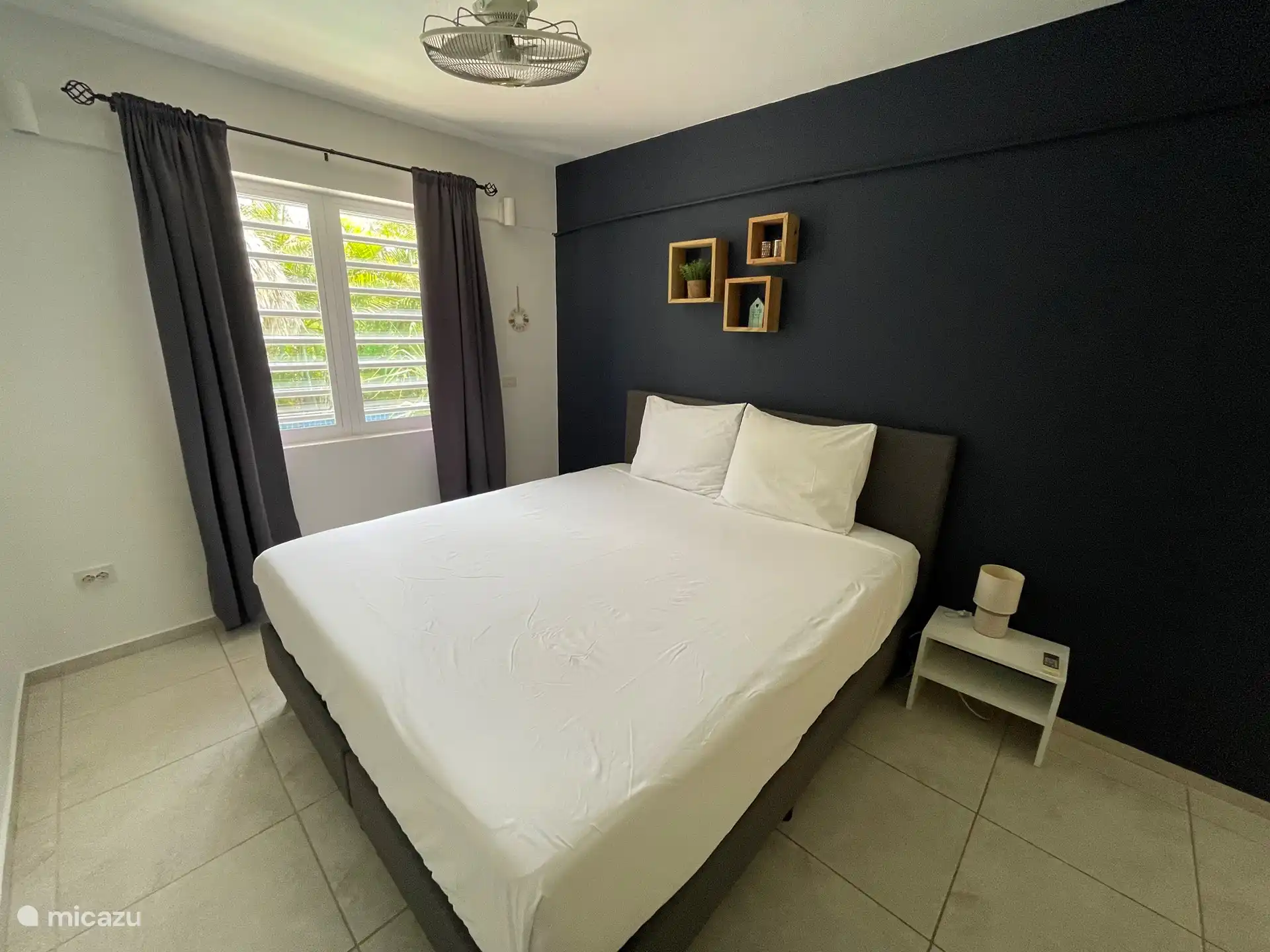 Schlafzimmer 1 verfügt über ein komfortables Boxspringbett, Klimaanlage, Deckenventilator und einen geräumigen Kleiderschrank.