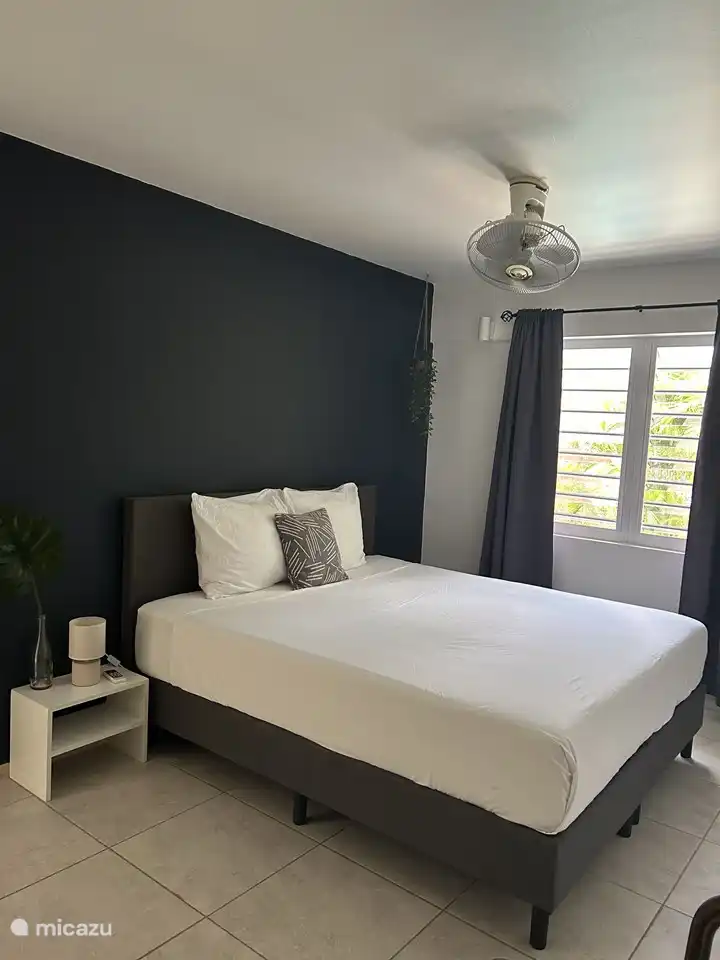 Schlafzimmer 2 ist mit einem komfortablen Boxspringbett, Klimaanlage, Ventilator und einem geräumigen Kleiderschrank ausgestattet.