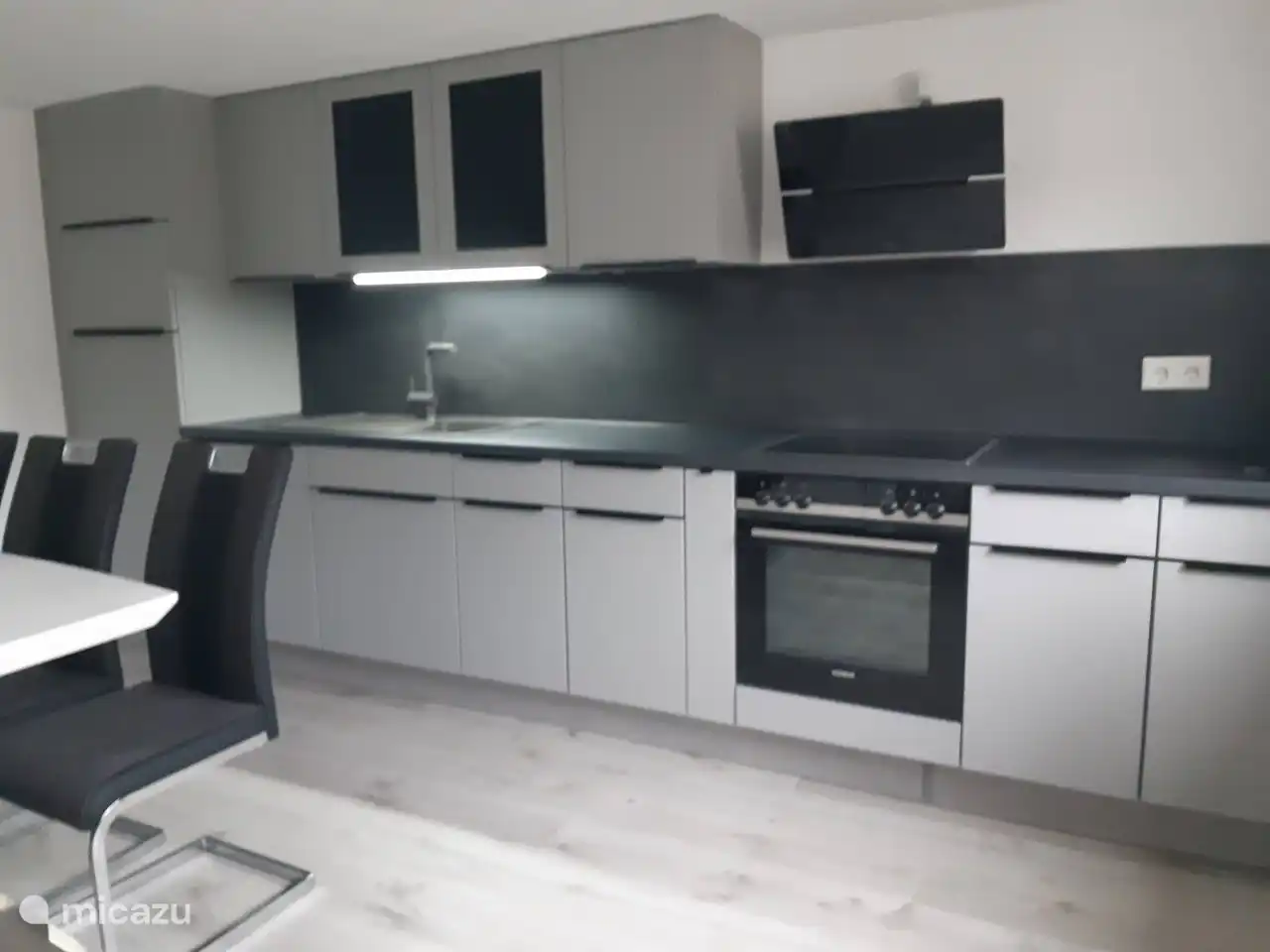 Küche mit Kühlschrank, Geschirrspüler, Backofen, Elektroherd, Filterkaffeemaschine und Mikrowelle. 