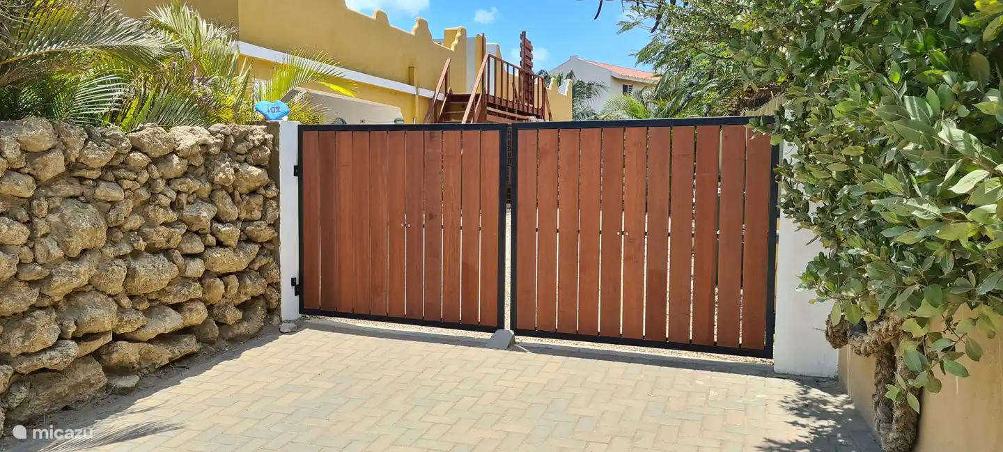 une belle porte d'entrée large avec télécommande pour garer la voiture à l'intérieur sur la propriété, mais à l'extérieur il y a aussi de la place sur une place de parking pavée devant la maison.