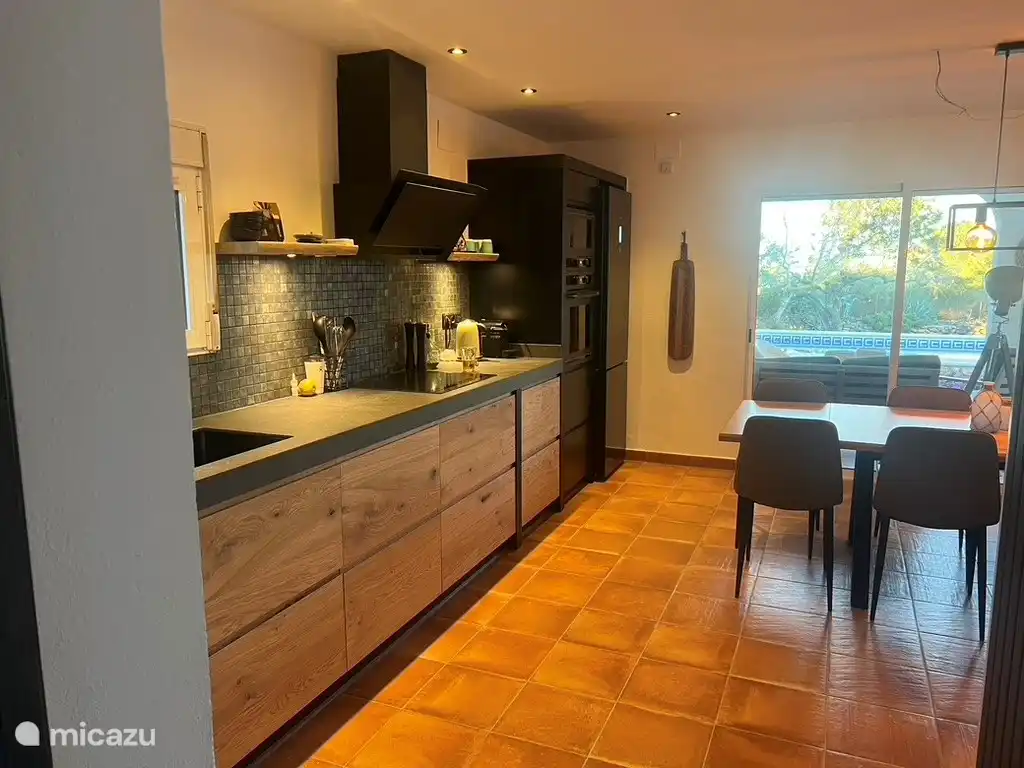 Küche mit Kühlschrank, Gefrierschrank, Induktionskochfeld, Backofen, Kombi-Mikrowelle und Geschirrspüler.